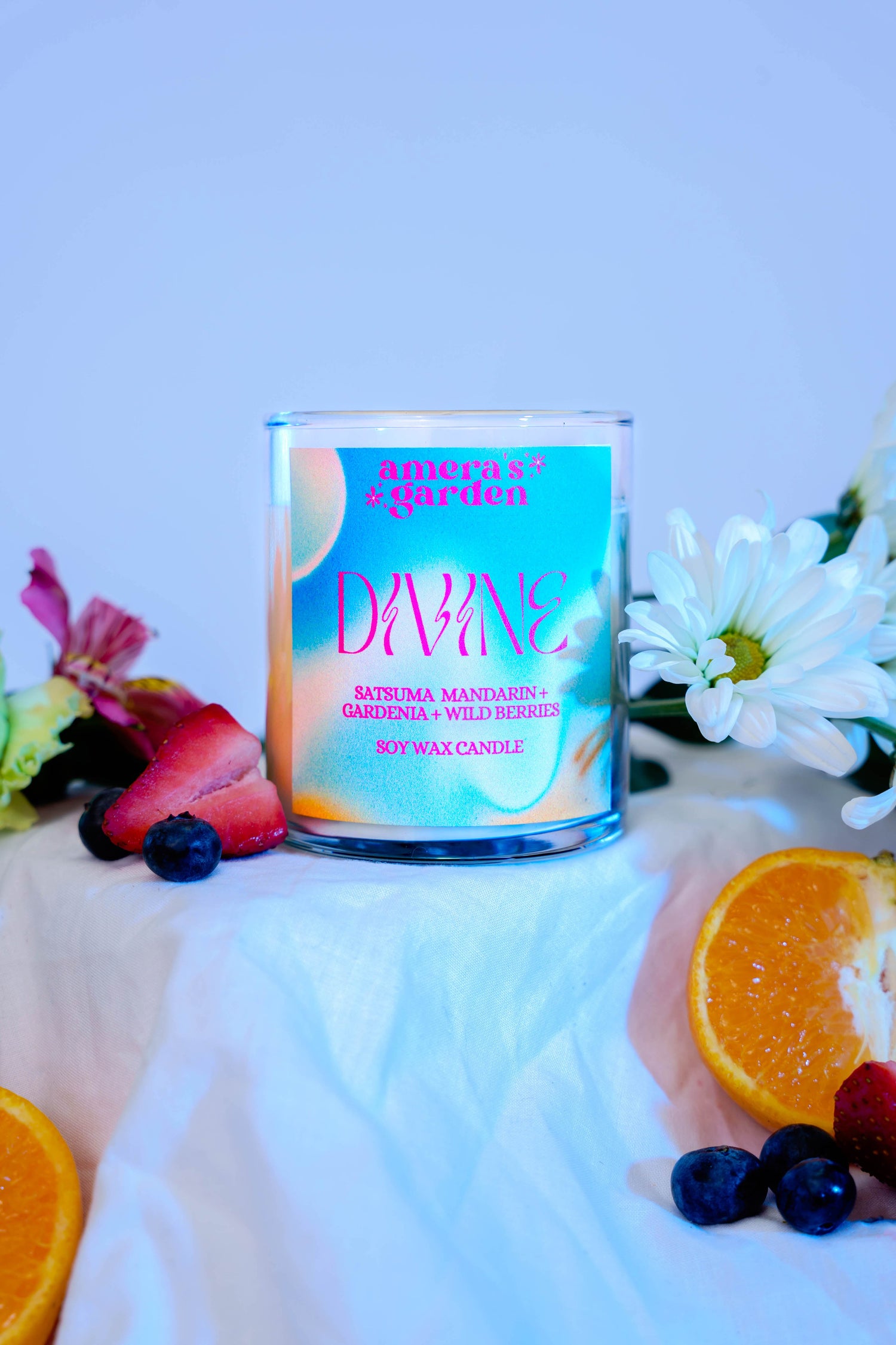divine candle in glass jar surrounded by fruit