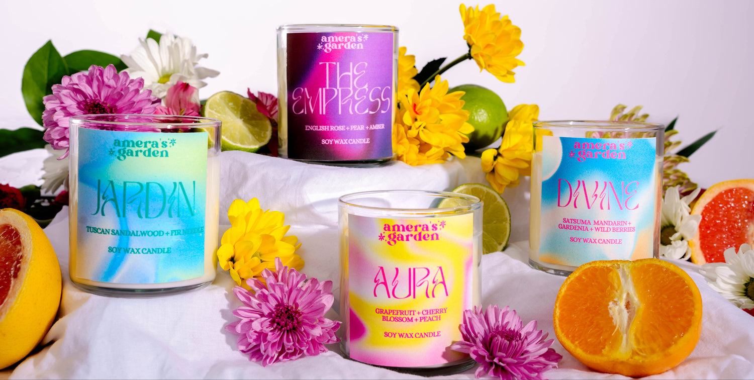Collection of colorful candles with floral and fruit decorations on a white surface